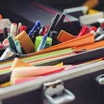 A collection of colorful office supplies neatly arranged in a suitcase, perfect for professionals on the go.